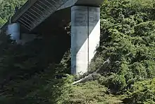竹割り型土留め工法。地形改変面積を縮小することで森林伐採範囲を縮小して環境負荷の低減を図っている。画像左 : 芝川高架橋の竹割り型土留め工法。この地の平均斜度は45度。従来の工法では山肌を大きく削り取ることになり、自然のバランスを大きく損なうところであった。画像右 : 宍原第一高架橋の同工法。
