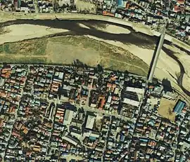 北を上にした八王子市田町付近の航空写真。浅川の南側、その部分だけが広くなっている東西に走る道路が田町遊廓の大路跡。写真北東の橋は暁橋。国土交通省 国土地理院 地図・空中写真閲覧サービスの空中写真を基に作成