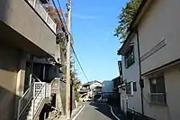 左右の家屋後方上部に鬼橋岩があった。西側から東方向を撮影。