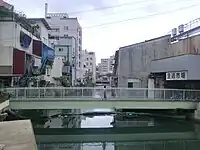「兵庫屋の臨時雇のあと、峯太郎は旦過市場の魚屋から塩鮭と塩鱒とを分けてもらい、旦過橋から一つ南の天神橋の上に立って売った。幅の狭い神岳川だが水面から吹き上げる川風は冷く、彼は水洟を手の甲で拭き拭きして、橋の上を往復する通行人を客引きのようにきょろきょろと見ていた」