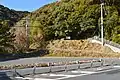 遠景中央に石室。手前は国道56号、左端には田ノ口小学校が所在。