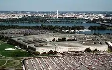 南西方向から見たペンタゴン。背景の川はポトマック川。その向こうがワシントンD.C.で、白い塔はワシントン記念塔(1998年)。