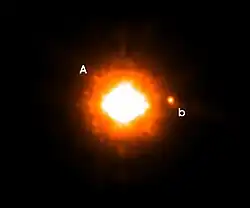 超大型望遠鏡VLT NACOによって撮影された、おおかみ座GQ星のKsバンド写真。中央のGQ星の右に写っている天体が、新たに発見された低温の伴星である。この伴星はGQ星の250分の1の明るさであり、離角は0.73秒角である。おおかみ座GQ星の距離にでは、これは100天文単位に相当する。画像上が北、左が東に相当する。