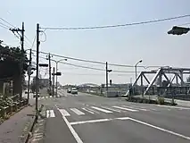 足利市・渡良瀬橋北交差点(通4丁目付近、2015年6月)五差路の交差点であり、↖(北東)方向が県道5号(至足利市街)、→(南・渡良瀬橋)方向が県道5号(至太田)、←↑↓方向が市道である。