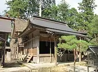 拝殿と本殿（奥）本殿は桁行3間梁間2間の神明造茅葺。外削ぎの千木を持ち、棟に鰹木を置く。かつては60年に1度の式年遷宮が行われていたという。現在の本殿は明治7年（1874年）の造替。