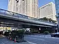 南西側の下から橋を見る。左は都庁第一本庁舎、中央は第二本庁舎、右は新宿NSビル。