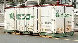 元祖センコーカラーの改変仕様で、2000年代より復活登場した鉄道輸送用、20ft型汎用コンテナ。国交省からの補助金を受けて導入された、積水ハウスの建材を運んでいるスワップ・ボディー仕様。床下の黄色い横長足を両側で同時に起こし、コンテナ全体を四足の起立状態にセット後に、荷台のないシャーシ状態の専用中型トラックを差し込む。（大阪府／安治川口駅にて、2011年4月3日撮影。）