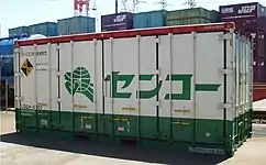 元祖センコーカラー仕様で、2000年代より復活登場した鉄道輸送用、20ft型汎用コンテナ。積荷の重量増大に対応した、フレコンに入った樹脂を運んでいる。試作品のためにこのカラーでは一個のみの登録となった。（岡山県／東水島駅にて、2003年4月22日撮影。）