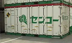 元祖センコーカラーの改変仕様で、2000年代より復活登場した鉄道輸送用、20ft型汎用コンテナ。積荷の重量増大に対応した、フレコンに入った樹脂を運んでいる。（岡山県／東水島駅にて、2003年5月18日撮影。）