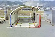 大幅な規制緩和の恩恵で、鉄道輸送での建築限界に対応して高級車を二段積みに出来る、ドーム屋根の新型コンテナも登場していた。※画像は、重箱の様に二段積み使用のコンテナの上部側を平面に置いて、ドーム屋根を片側へ半開きにして、車を出し入れする作業員の便宜を図っている状態の風景。1995年4月撮影、福岡県／旧苅田港駅。