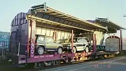 客車状の背高貨車に包み込むように積載すると言う、新しい発想で開発された、カーラックコンテナ。このコンテナは、一枚板状の床面が水平に上昇して、二段式に分かれるので、車種により二台～四台積載できる。1995年11月18日、愛知県／名古屋(タ)。