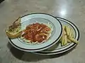 アメリカのデニーズのスパゲティ。副菜としてポテトとパンがついてくる。