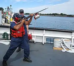 USCGC カトマイベイ (WTGB-101)（英語版）艦上にてスプリングフィールドM1903小銃改造の索発射銃を構える米国沿岸警備隊員(2013年)