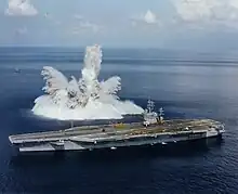 本艦のすぐ近くで機雷か何かがまとめて爆発しているらしく、巨大な波しぶきがあがっています。波しぶきはウミの中から現れた白く大きな不定ケイの怪物のようにも見えます。