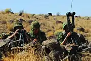 88式鉄帽を着用して砲隊鏡を使用する陸上自衛隊員