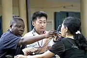 バイタルサインのチェック。（アメリカ海軍の衛生下士官と日本の医療専門家によるベトナム女性の状態の確認）