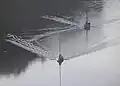 ゆっくり航行している2艘の小型船の航跡。手前の船は定規で引いたかのような目覚ましい波を作っている。