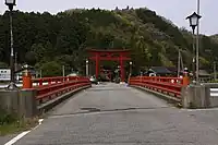 一の鳥居県道81号線より。奥にある二の鳥居の背後に妹背山。手前の朱塗りの欄干は羽茂川に架かる橋で、往古にはこの川の洪水により社殿や別当坊など全てが流失した。