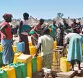 難民キャンプで、水を汲む避難民