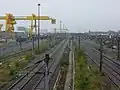 ノース・ロンドン線ホームから撮影したウェスト・コースト本線。草が茂っている線路間の隙間にかつては同線のホームが設置されていた。