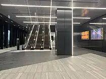 ウエストタワー2階アトリウム、建設時の作業音等のデータをパターン化してジャカード織で制作した田島美加（英語版）のパブリックアートを壁に設置（2024年5月撮影）