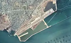 1974年に撮影された、県営宇部空港時代の空中写真。当時の滑走路延長は1,200メートル。沖合いを埋め立てて滑走路を移転・拡張されたことが左記2022年撮影空撮画像との比較で分かる。国土交通省 国土地理院 地図・空中写真閲覧サービスの空中写真を基に作成。1974年撮影の2枚を合成作成。