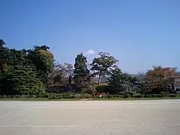 梁川城本丸跡にある伊達市立梁川小学校の校庭に復元された中世庭園「心字の池」。中央奥の石垣は、本丸の物見櫓跡。発掘調査では、この小学校校庭の場所に本丸館があった。
