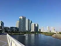 ポートサイド地区のマンション群と帷子川との間に細長くのびる緑地がポートサイド公園である。奥は横浜市中央卸売市場本場、そのさらに奥がコットンハーバー地区（2020年9月）