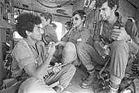 第4次中東戦争にてUH-1ヘリ機内でUZIを抱えるイスラエル国防軍の兵士(写真左)（1973年）