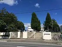 陽明小学校正門バス通り（阪急バス・陽明小学校前バス停）から見た陽明小学校正門。歩行者用階段と自動車用スロープがある。正門から中庭・校舎方面へメタセコイアの並木が続く。