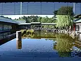 回廊から見た庭園。庭園の石材には、一時代に活躍していたものを再利用しているものが多くある。また、水田をイメージして、１年中緑色をしている「ネビキグサ」を植えている。