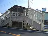 旧西口の外階段ホーム同士をつなぐ跨線橋がそのまま駅の西側の道路（神奈川県道205号金沢逗子線）に達し、西口となっている（移転前のもの。2004年11月）。