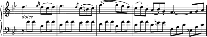 \relative c' {
\new PianoStaff <<
\new Staff \with { \remove "Time_signature_engraver" } { \key bes \major \time 6/8
d'4._\markup \italic dolce \slashedGrace es8 d( c d) es4. \slashedGrace d8 c( b c)
f4.~( f8 es d) c( d-.) bes-. a( bes-.) g-. f4.~ f8 g a
}
\new Staff \with { \remove "Time_signature_engraver" } { \key bes \major \time 6/8 \clef bass
r8 f f bes, f' f c f f es f f d f f bes, f' f c f f c e e f, a c es,! a c
}
>>
}